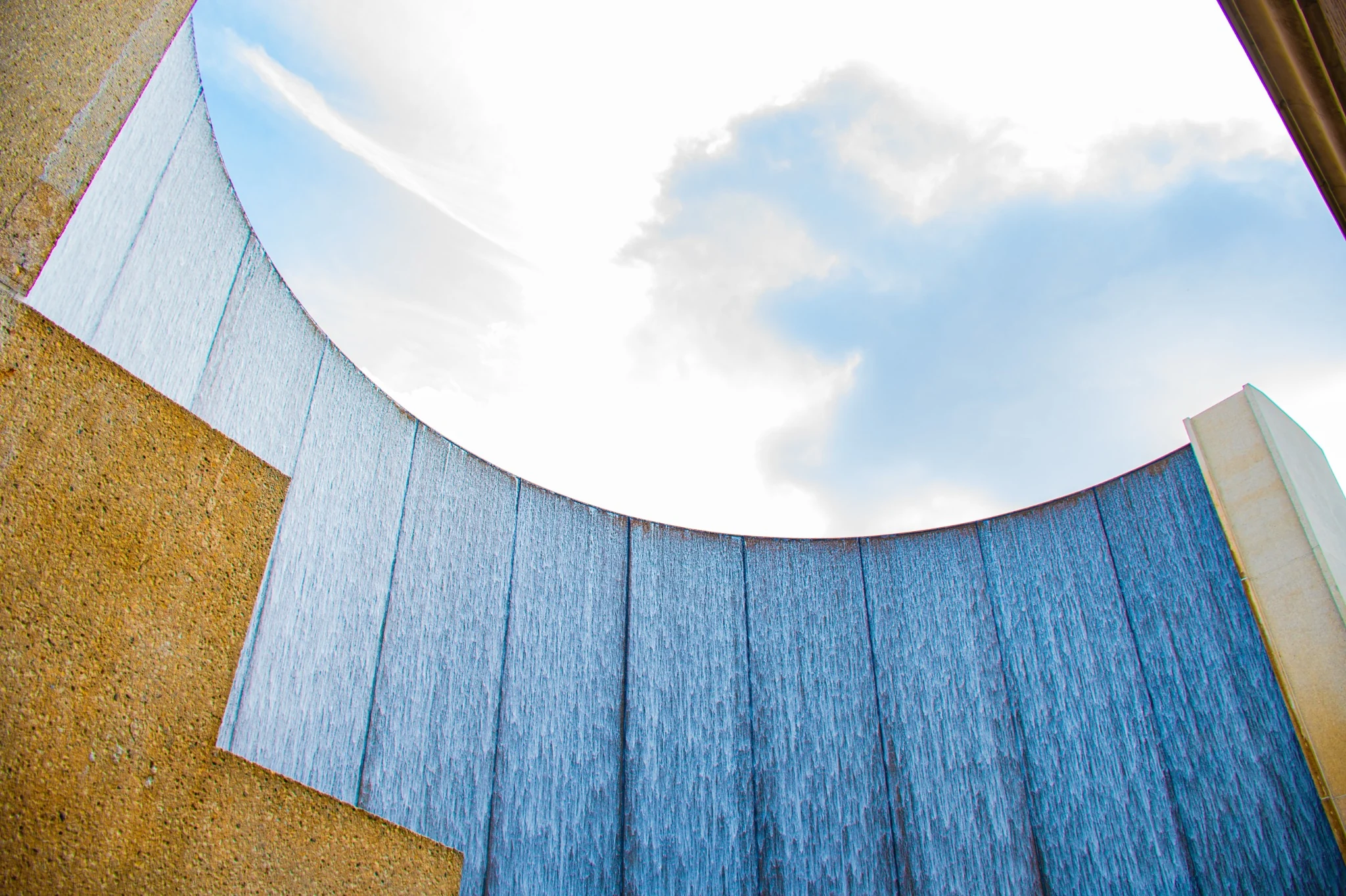 Curved blue water wall feature in Houston