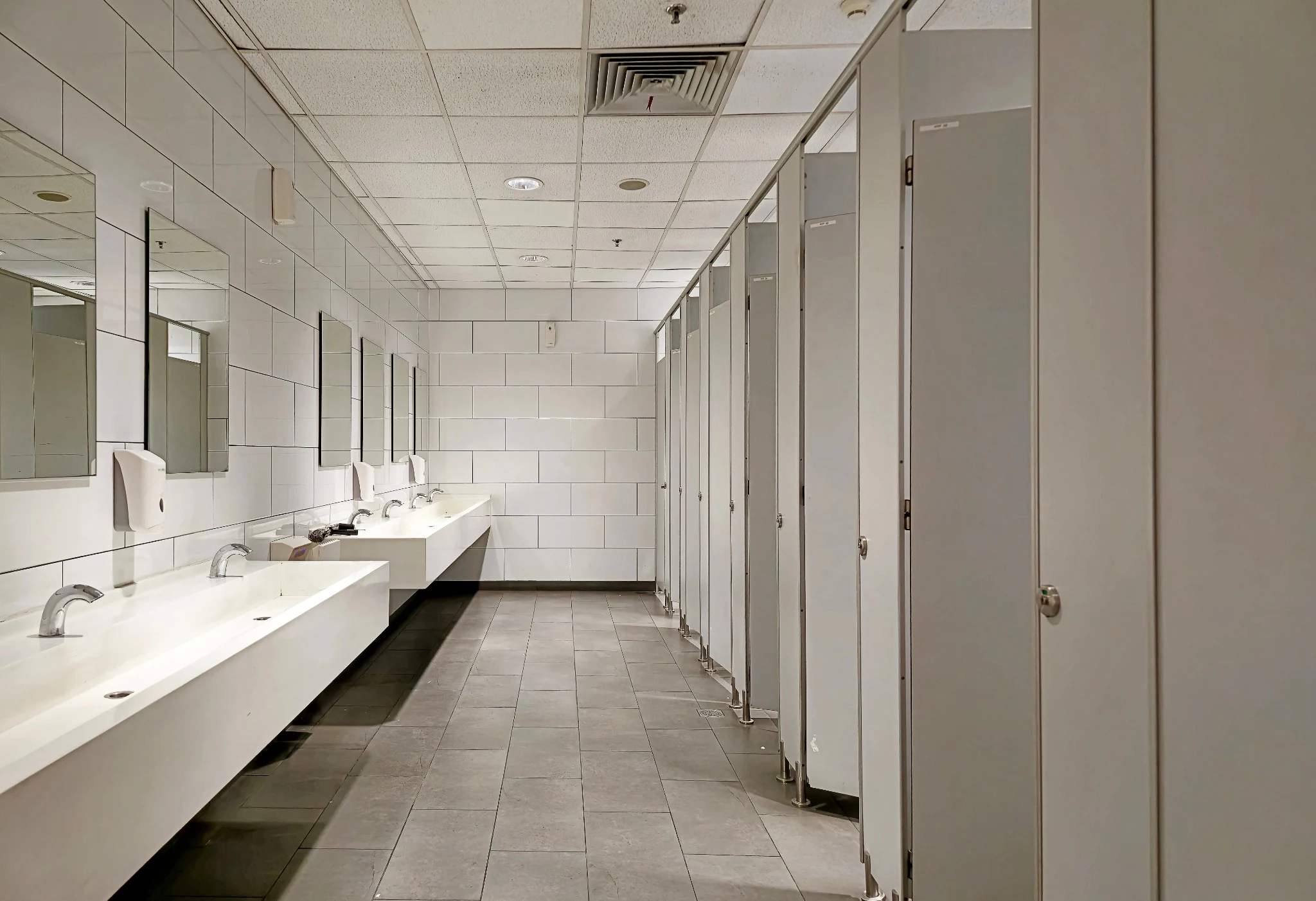 Sinks and stalls in a commercial office restroom